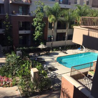 A view of an apartment complex courtyard with a swimming pool and garden.