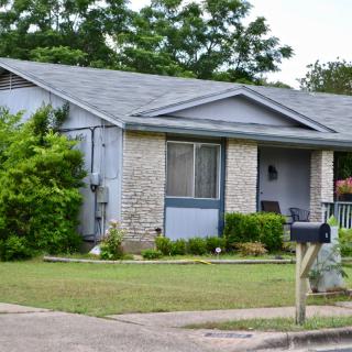 A suburban house with a manicured yard and a mailbox by the curb.