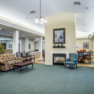 A cozy lounge with comfortable seating, a fireplace, and artwork on the wall.
