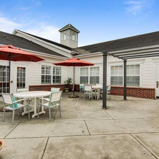 An inviting outdoor patio area with tables, chairs, and umbrellas next to a building.