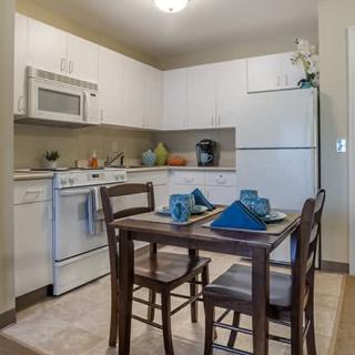 A cozy kitchen and dining area with a set table and modern appliances.