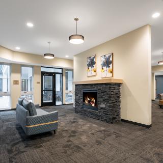 A modern lobby with a stone fireplace, comfortable seating, and contemporary artwork.