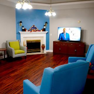 A cozy living room featuring comfortable seating, a television, and a decorative fireplace.