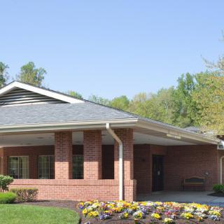 A suburban brick building surrounded by well-maintained landscaping and greenery.