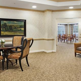 A cozy dining area with elegant furniture and artwork on the wall.