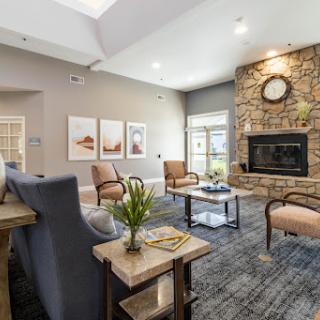 A modern living room featuring a cozy atmosphere with a stone fireplace and stylish seating.