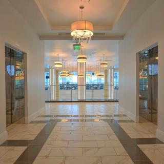 A modern hallway with elevators and elegant lighting fixtures.