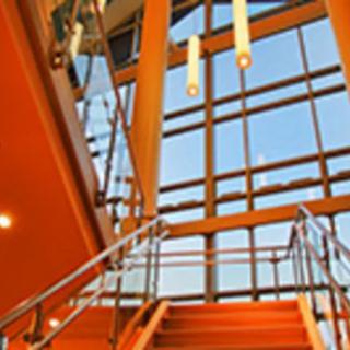 A modern interior featuring a staircase with large glass windows and contemporary lighting.