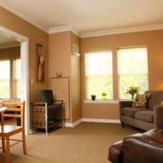 Cozy living room with warm tones, a comfortable sofa, and ample natural light.