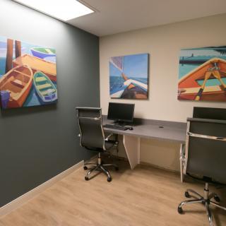 A modern office space with computers and vibrant paintings on the walls.