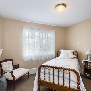 A cozy bedroom with a single antique bed and vintage decor.