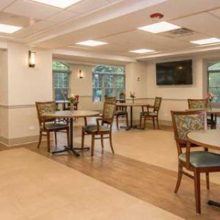 A cozy indoor dining area with tables and chairs, featuring a television on the wall.