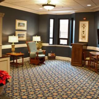 A cozy waiting room featuring comfortable furniture, decorative lamps, and a patterned carpet.