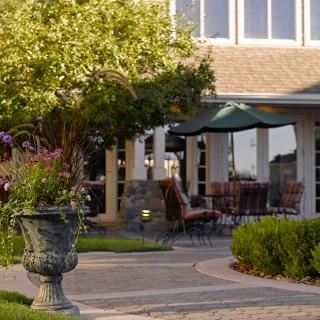 A cozy patio with outdoor seating and lush garden landscaping.