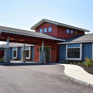 A modern building with a welcoming entrance and a curved driveway.