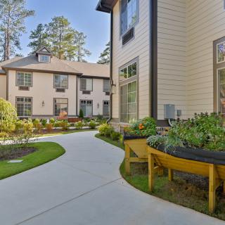 A scenic outdoor view featuring a garden path surrounded by modern buildings.