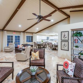 Spacious living room with modern decor, featuring wood ceiling beams and a ceiling fan.