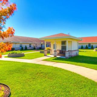 A scenic view of a building surrounded by a well-manicured lawn and garden.