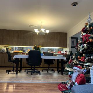 A cozy dining room decorated with a Christmas tree and holiday ornaments.