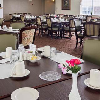 An elegantly set dining room with neatly arranged tables and chairs, ready for guests.
