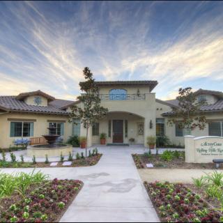 A well-maintained residential house with a beautifully landscaped front yard under a picturesque sky.