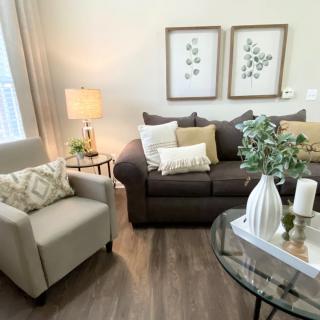 A cozy and well-decorated living room with a brown sofa, beige armchair, and stylish accessories.