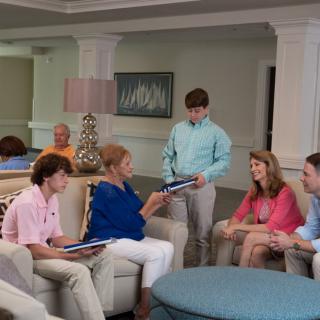 A group of people having a conversation in a living room setting.