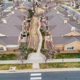 Aerial view of a residential neighborhood with neatly arranged houses and landscaped pathways.