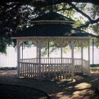 A charming gazebo surrounded by lush trees, providing a peaceful retreat in the park.
