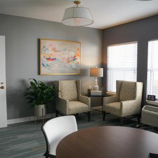 A modern living room with neutral tones, featuring comfortable seating and artistic decor.