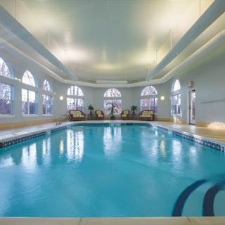 A luxurious indoor swimming pool with elegant architecture and ambient lighting.