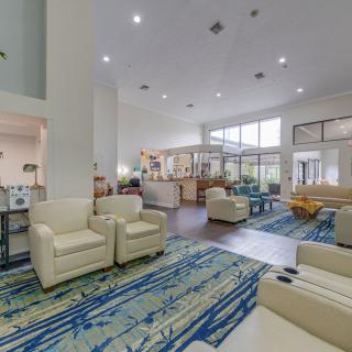 A spacious lobby with modern furniture, featuring a seating area and a reception desk.