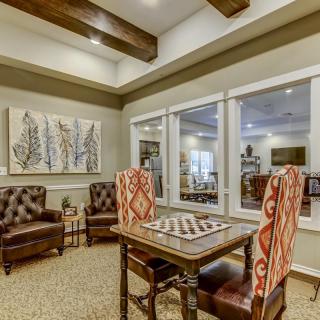 A cozy living area featuring a table with patterned chairs and stylish artwork on the wall.