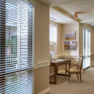 A quiet office corridor with a table and chairs by the window.