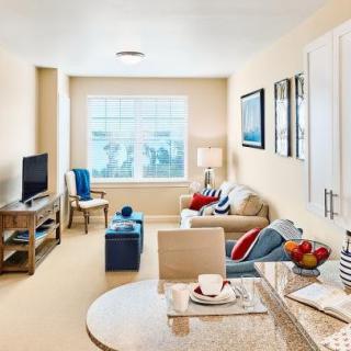 A cozy and well-decorated living room with light-colored walls, a comfortable sofa, and modern furnishings.