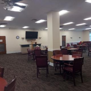 A spacious dining area featuring tables and chairs, designed for communal gatherings.