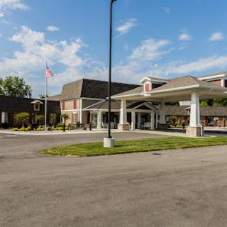 A welcoming hotel entrance with a spacious parking area under a clear blue sky.