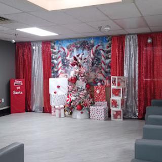A beautifully decorated holiday event space featuring a Christmas tree and themed decorations.