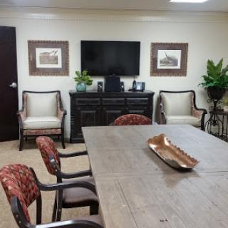 A well-furnished meeting room equipped with a television and comfortable seating.