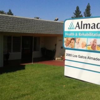 A small healthcare clinic with a sign reading 'Almaden Health & Rehabilitation.'