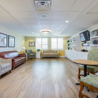 A spacious living room with comfortable seating, a television, and ample natural light.