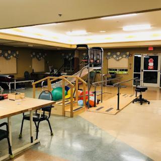 A spacious rehabilitation therapy room equipped with various exercise tools and accessible features.
