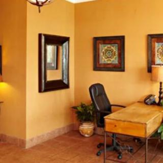 A cozy office space with a wooden desk, chair, and decorative wall art.