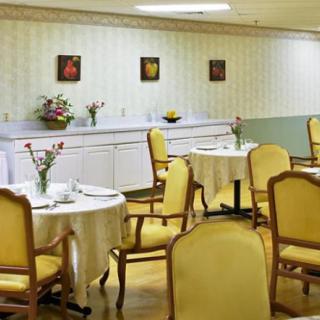 A neatly arranged dining room with tables, chairs, and subtle floral decor.
