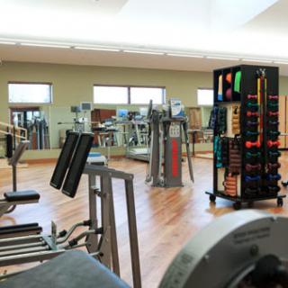 A well-equipped gym featuring various exercise equipment and a spacious workout area.