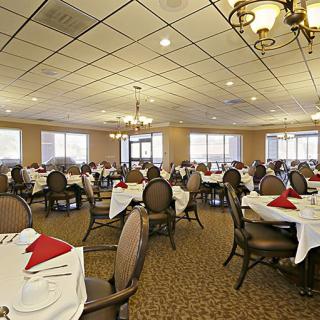 A spacious banquet hall with neatly arranged tables and chairs, set for dining.