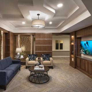A modern living room with elegant furniture and a built-in aquarium.