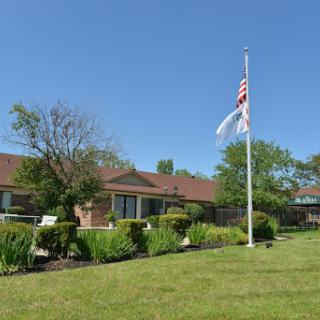 A peaceful residential building with a flag flying against a clear blue sky.