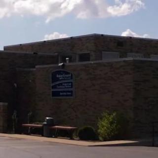 A brick building under a partly cloudy sky.