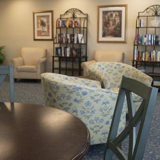 A cozy seating area featuring armchairs, bookshelves, and framed artwork.